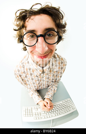 View from above of man in glasses sitting at desk with keyboard on it Stock Photo