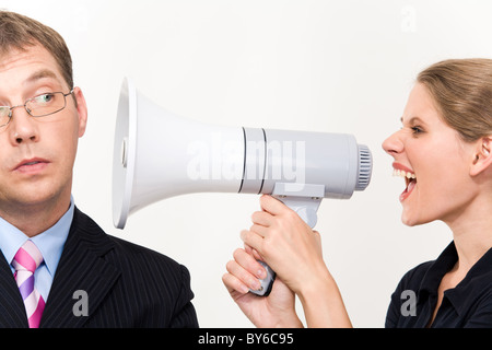 Close-up of young furious woman screaming at her boss through megaphone Stock Photo
