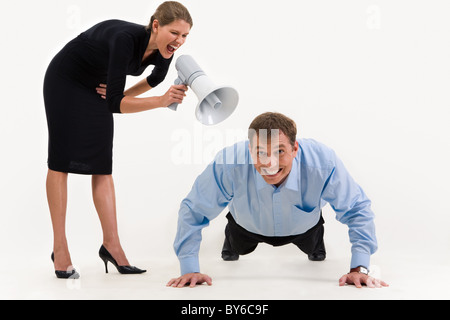 Image of businesswoman standing and screaming at businessman doing a exercise Stock Photo