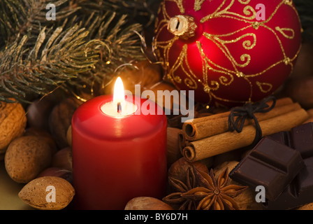 Christmas decoration with candlelight, nuts and bauble as closeup Stock Photo