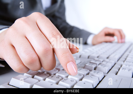 Macro image of human hand with forefinger going to press key on keyboard Stock Photo