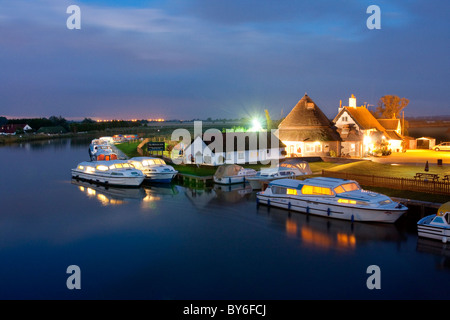 Boat mored up next to Acle Bridge at night on the Norfolk Broads Stock Photo