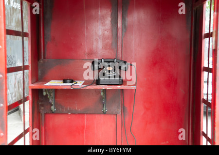 Old telephone in traditional red telephone booth Stock Photo