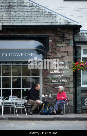 A couple sit outside of a cafe in Grasmere in the Lake district Stock Photo