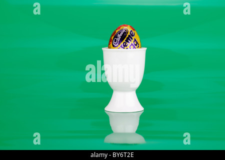 Cadbury creme egg in a white egg cup Stock Photo