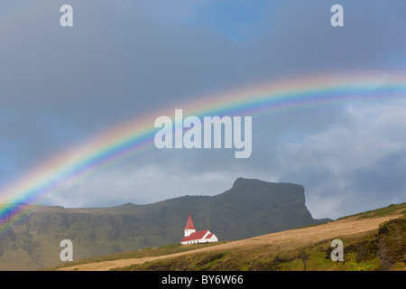 Rainbow over church, Vik, Iceland Stock Photo