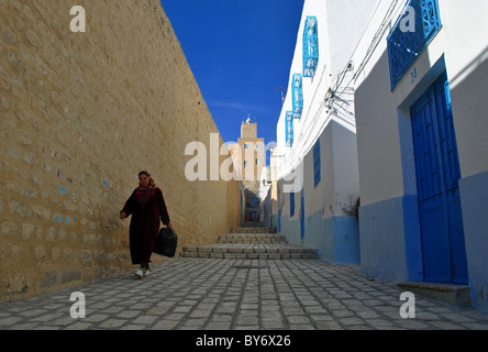 Woman walking down a street in Sousse medina, Tunisia Stock Photo