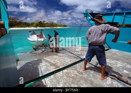 Loading boat onto barge just offshore from North West Island, southern Great Barrier Reef Marine Park, Australia. No MR or PR Stock Photo