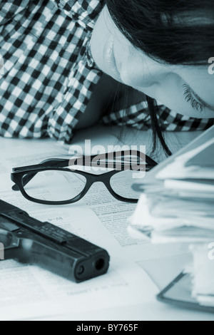 Female kild her self while filling out tax forms while sitting at her desk. Stock Photo