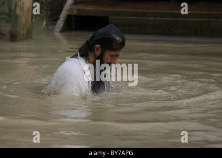 An Orthodox Christian pilgrim baptizing at the baptismal site of Qasr el Yahud in the Jordan River Valley region of the West Bank Israel Stock Photo