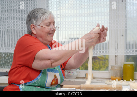 Elderly woman kneading dough Stock Photo