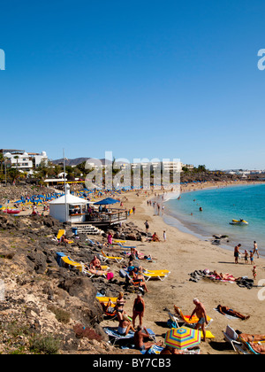 Busy Playa Dorada beach in Playa Blanca Lanzarote on a hot day in early January Stock Photo