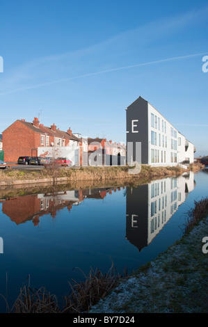 Modern apartments on the Coventry Canal contrasting with old traditional terraced housing to the rear, West Midlands, UK Stock Photo