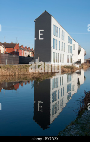 Modern apartments on the Coventry Canal contrasting with old traditional terraced housing to the rear, West Midlands, UK Stock Photo