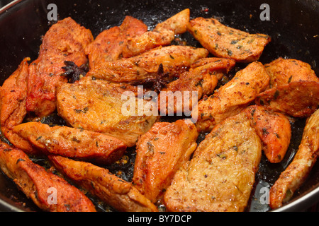 Asian spiced chicken in frying pan cooking from low perspective. Stock Photo