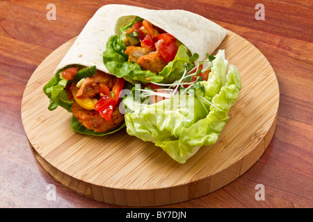 Spicy chicken with salad and salsa wrapped in a soft flour tortilla. Stock Photo