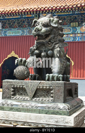 Asia, China, Beijing. Bronze sculpture of male lion, one of traditional imperial guardian pair; Tibetan Buddhist Lama Temple. Stock Photo