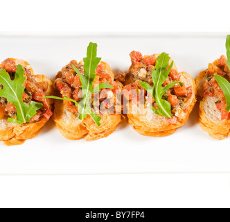 fresh tipycal italian bruschetta with tomato and arugula on top Stock Photo