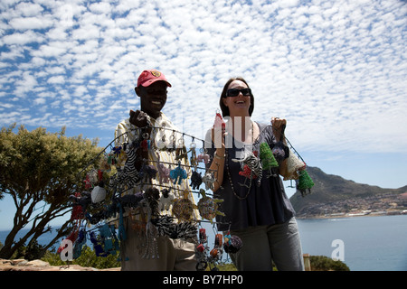 Street vendor artist selling handicrafts in Hout Bay with tourist Stock Photo
