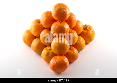 Clementines arranged in a pyramid shape isolated on white background Stock Photo