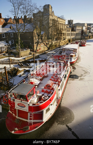 Pleasure boats moored on the frozen River Ouse near Lendal bridge, York, United Kingdom. Stock Photo