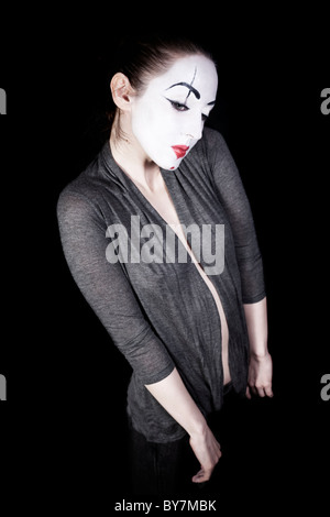 Sad woman mime in grey jacket on black background Stock Photo