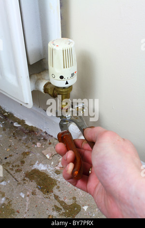 DIY plumber repairing a leaky radiator pipe, UK Stock Photo