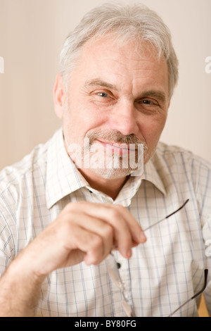 Senior mature man thoughtful with glasses looking at camera Stock Photo