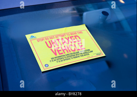 untaxed warning sticker attached to windscreen of vehicle warning not to move clamped vehicle uk Stock Photo