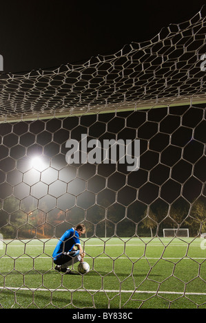USA, California, Ladera Ranch, goalie on illuminated soccer field at night Stock Photo