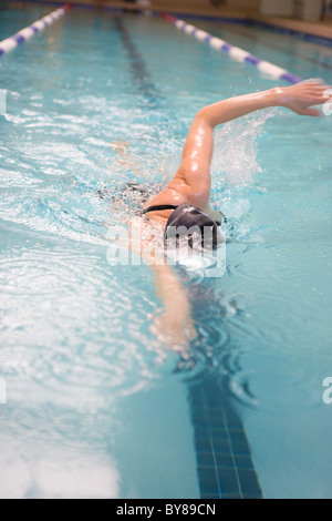 A woman swimming laps in an indoor pool Stock Photo