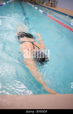 Female swimmer doing laps in an indoor pool Stock Photo