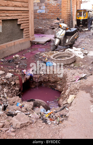 India, Rajasthan, Jodhpur, smashed man-hole cover in dilapidated street Stock Photo