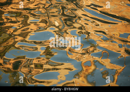 water reflecting golding colors in abstract patterns Stock Photo