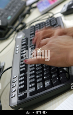 Two hands typing on a computer keyboard Stock Photo