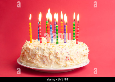 birthday cake with lots of candles on a red background Stock Photo