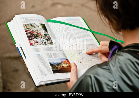 A tourist looking here map inside a traveler book in Montmartre, Paris, France Stock Photo