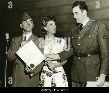 DINAH SHORE (1916-1994) US singer with comedian Eddie Cantor at left presenting an award to Cpl Ralph Wheleham about 1942 Stock Photo