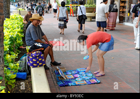 Shoppers walk on Kalakaua Ave along Waikiki Beach Honolulu Hawaii Stock Photo