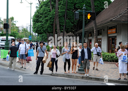 Shoppers walk on Kalakaua Ave along Waikiki Beach Honolulu Hawaii Stock Photo