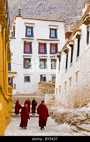 Tibetan monks walking on packed snow at Drepung Monastery, Lhasa, Tibet. JMH4552 Stock Photo