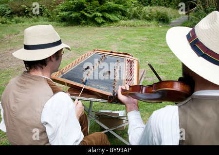 Musicians playing the hammered dulcimer and fiddle in Hoveton Hall Gardens Stock Photo