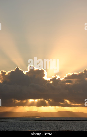 Golden sunset behind clouds Stock Photo