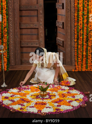 South Indian woman making a flower rangoli Stock Photo