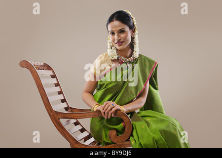 South Indian woman sitting on an arm chair Stock Photo