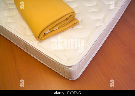 Mattress and yellow blanket Stock Photo