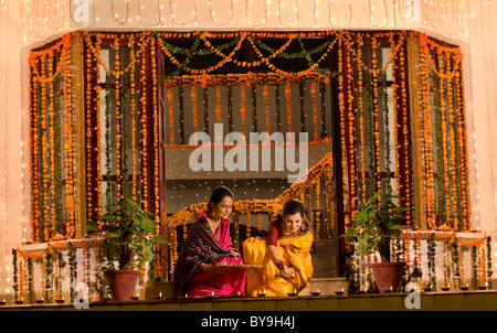 Mother and daughter arranging diyas Stock Photo