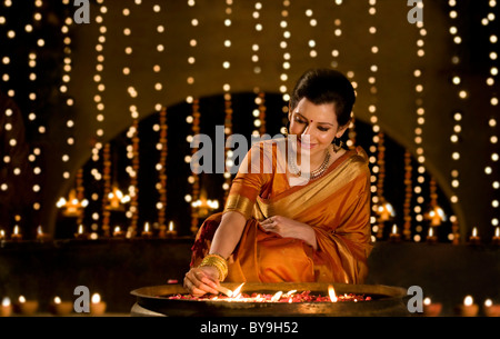 Woman lighting diyas Stock Photo