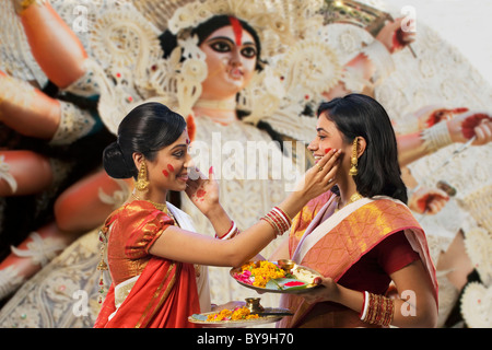 Bengali women putting colour on each others faces Stock Photo