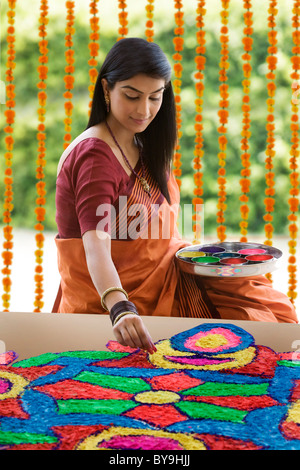 Indian woman making a Rangoli festival design in an Indian street at ...